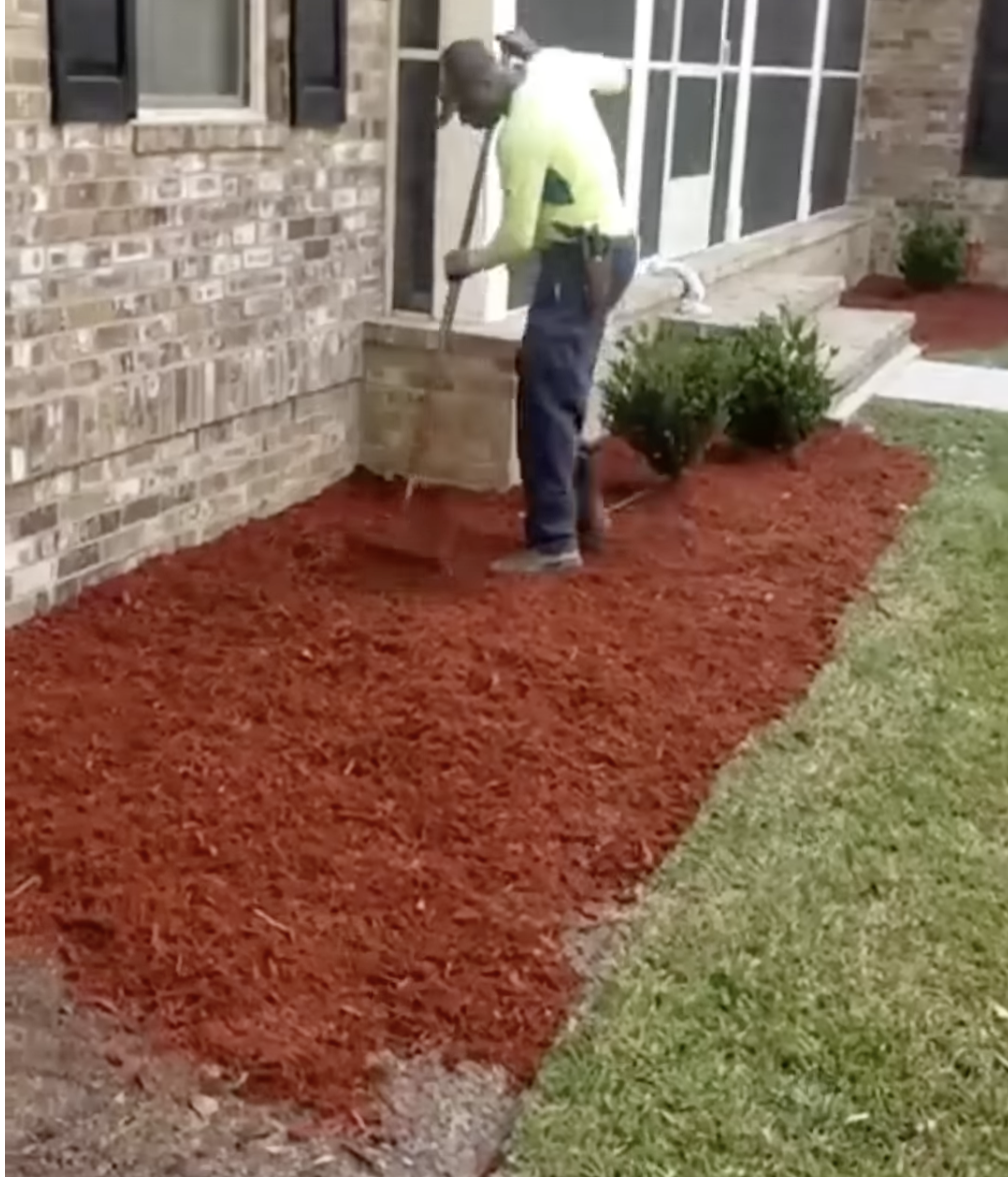Fresh red mulch installation around a brick home